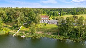 A large, two-story building with a flat roof and a central courtyard. - Seehotel Mühlenhaus (Chorin)