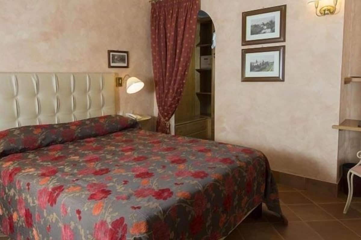 A bedroom with a bed, a desk, a chair, and a wardrobe.