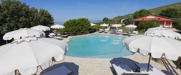 Piscine extérieure, parasols de plage, chaises longues