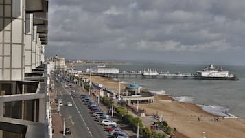 A coastal cityscape with a promenade, beach, and pier.