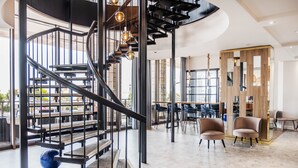 Een modern interieur met een spiltrap, zithoek en grote ramen.