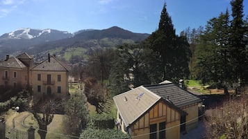 Un paisaje montañoso con un edificio grande rodeado de árboles.