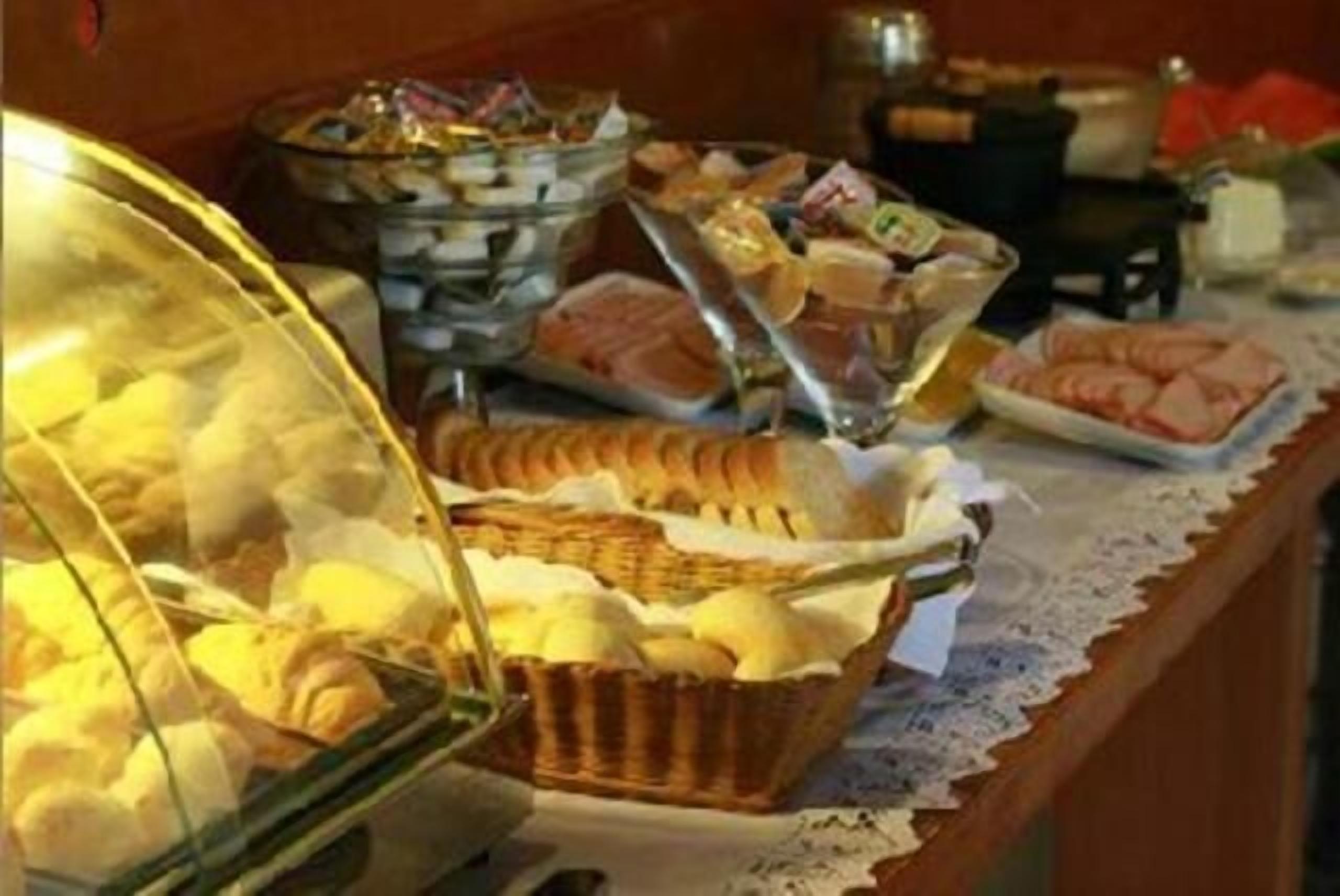 Un bufé con diversos alimentos, incluyendo pasteles, carnes y quesos.