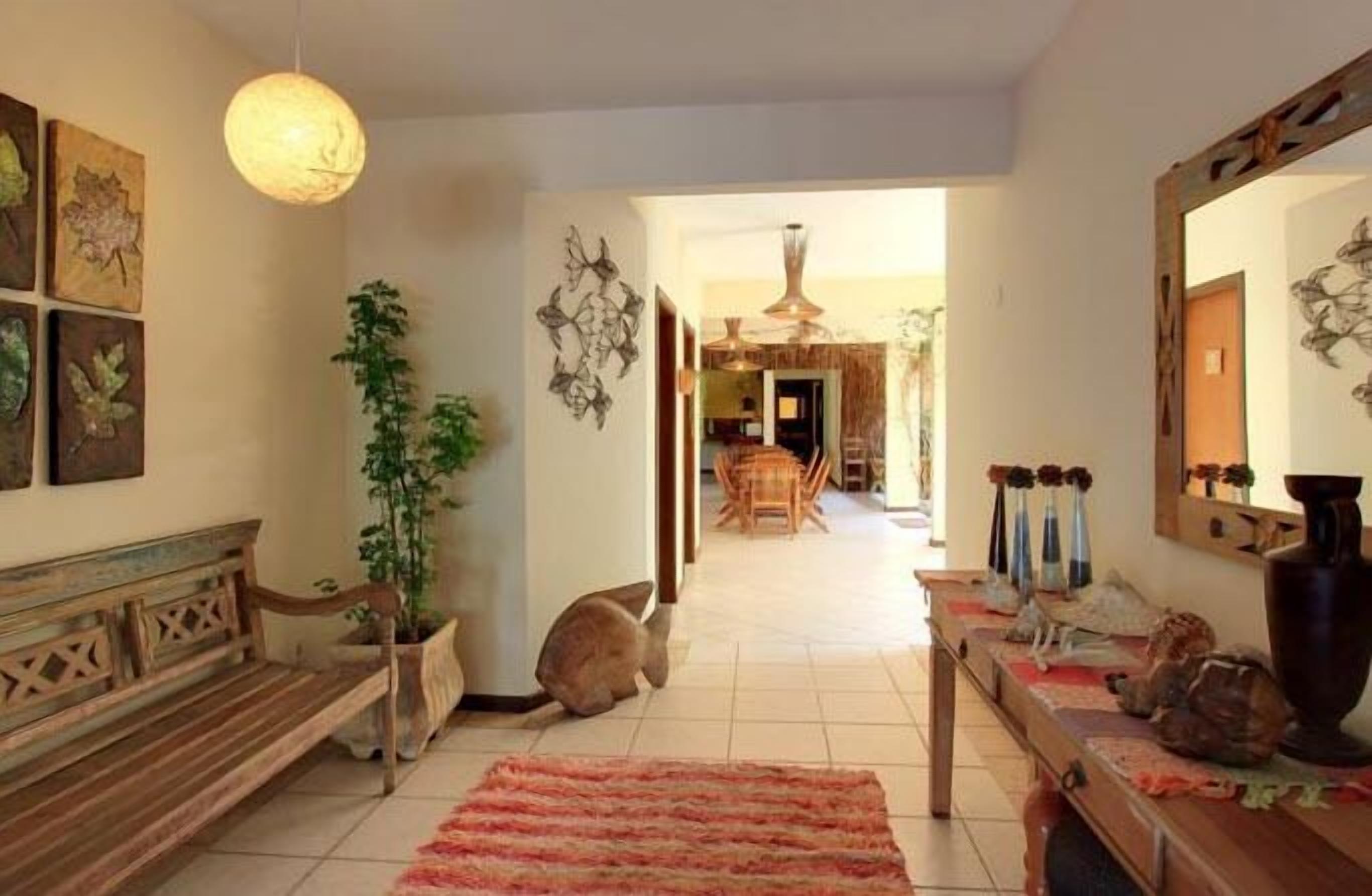 A cozy living room with a wooden bench, a potted plant, and a cat.