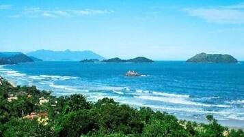 Perto da praia, areia branca, espreguiçadeiras, guarda-sóis