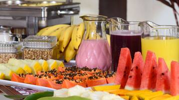 A buffet with various fruits and beverages.