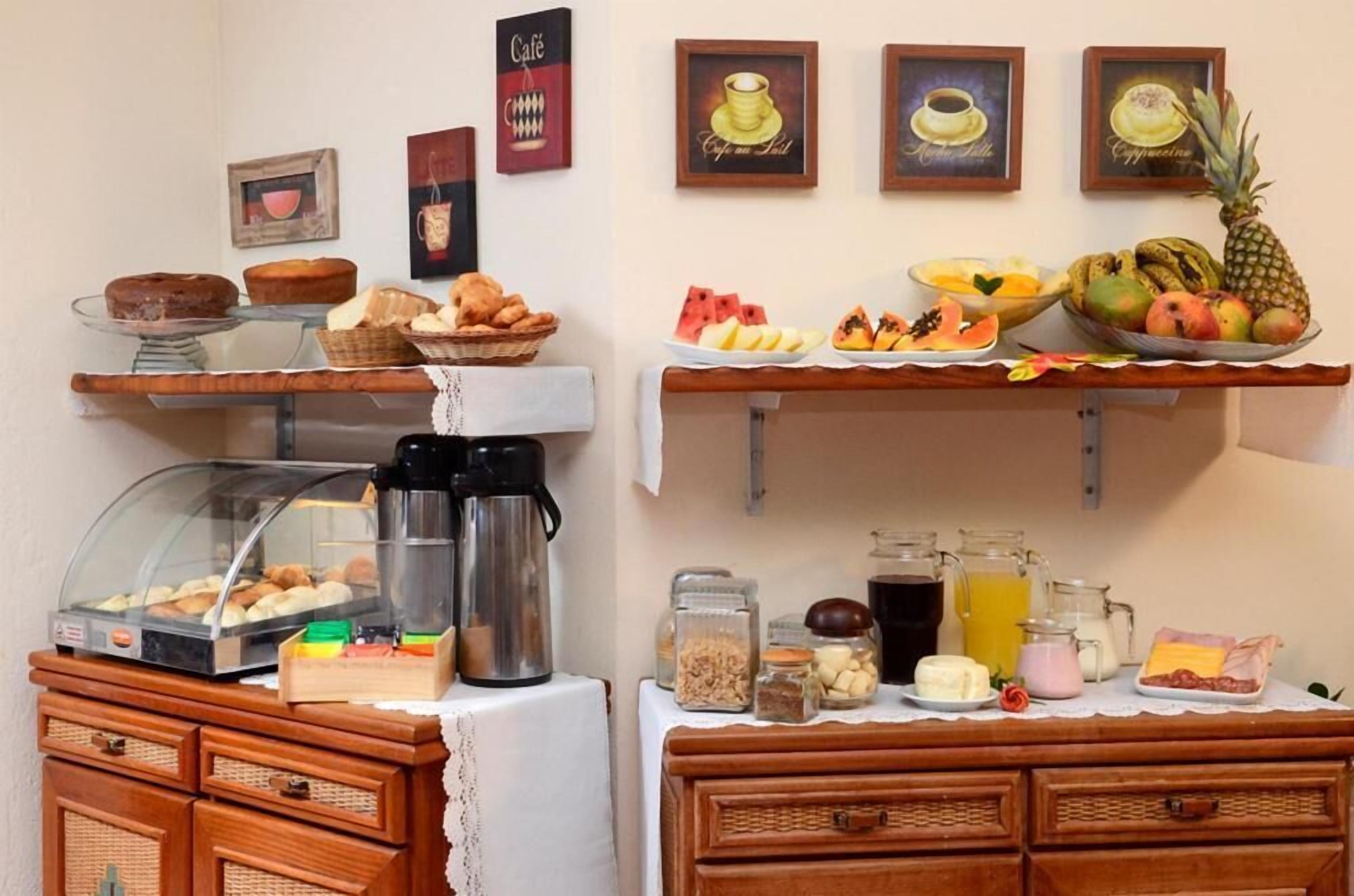 Un bufé de desayuno con diversos pasteles, frutas y bebidas.