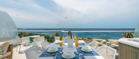 Mesa lista para el desayuno con vista al océano.
