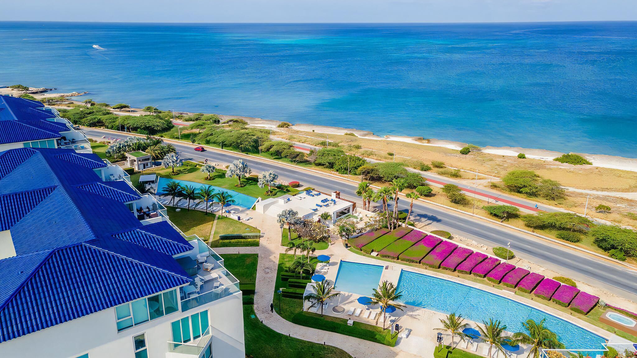 Un complexe hôtelier doté d’une piscine, d’un accès à la plage et offrant une vue sur l’océan.