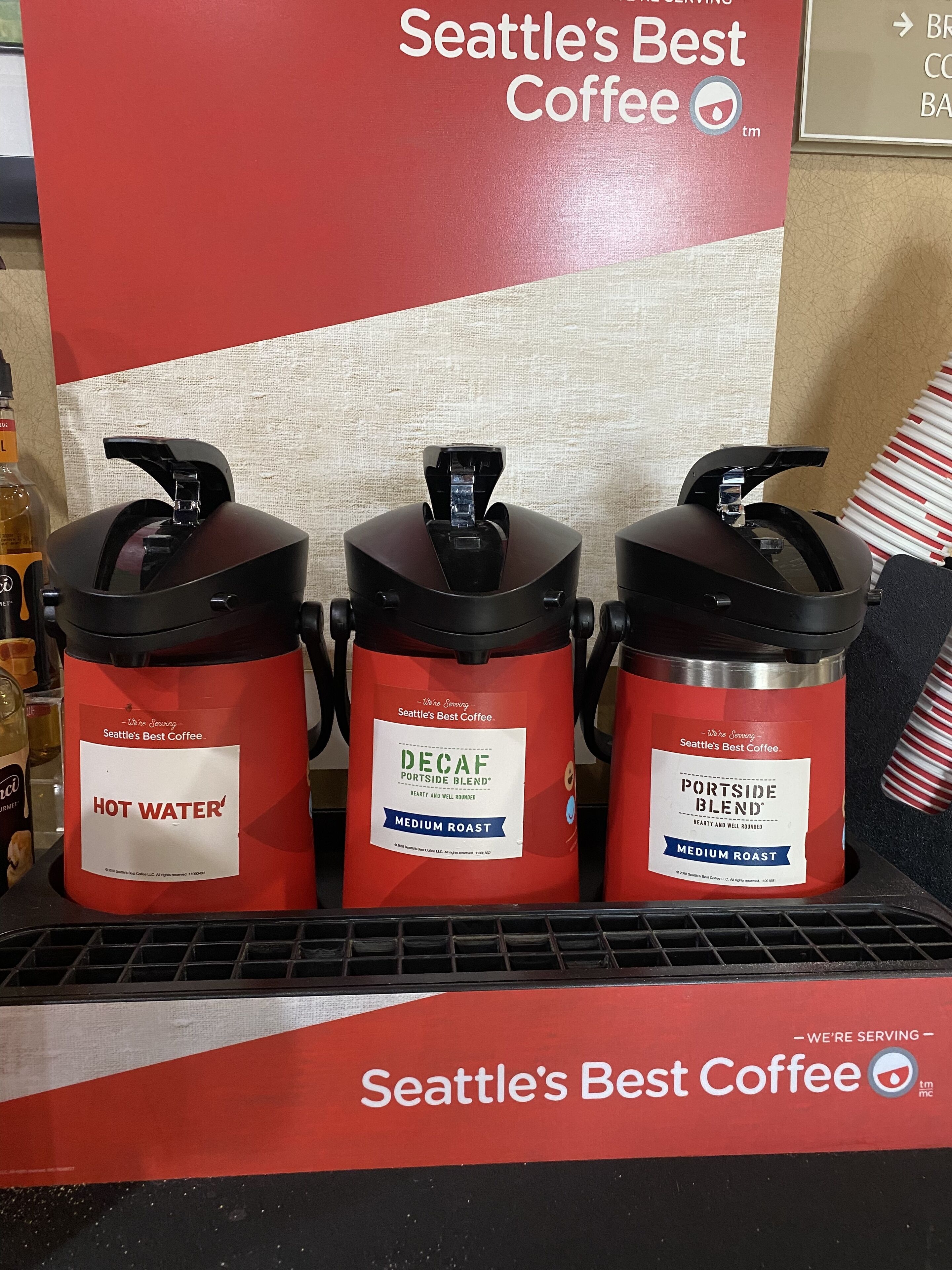 Three coffee dispensers labeled "Seattle's Best Coffee" with "Hot Water," "Decaf Portside Blend," and "Portside Blend" options.
