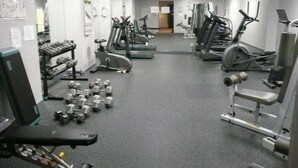 A gym with various exercise equipment including treadmills, stationary bikes, and free weights. - MondeLiving City Condo (Vancouver)