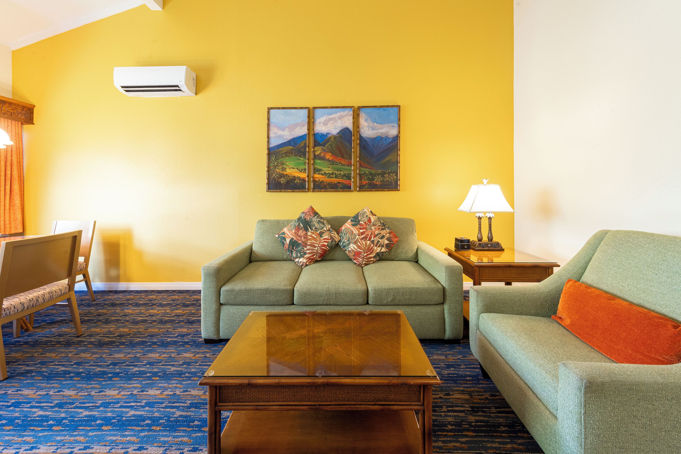 Una sala de estar con un sofá, una mesa de centro, una lámpara y un cuadro en la pared.