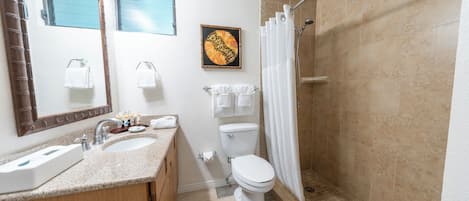 A bathroom with a sink, toilet, and shower.
