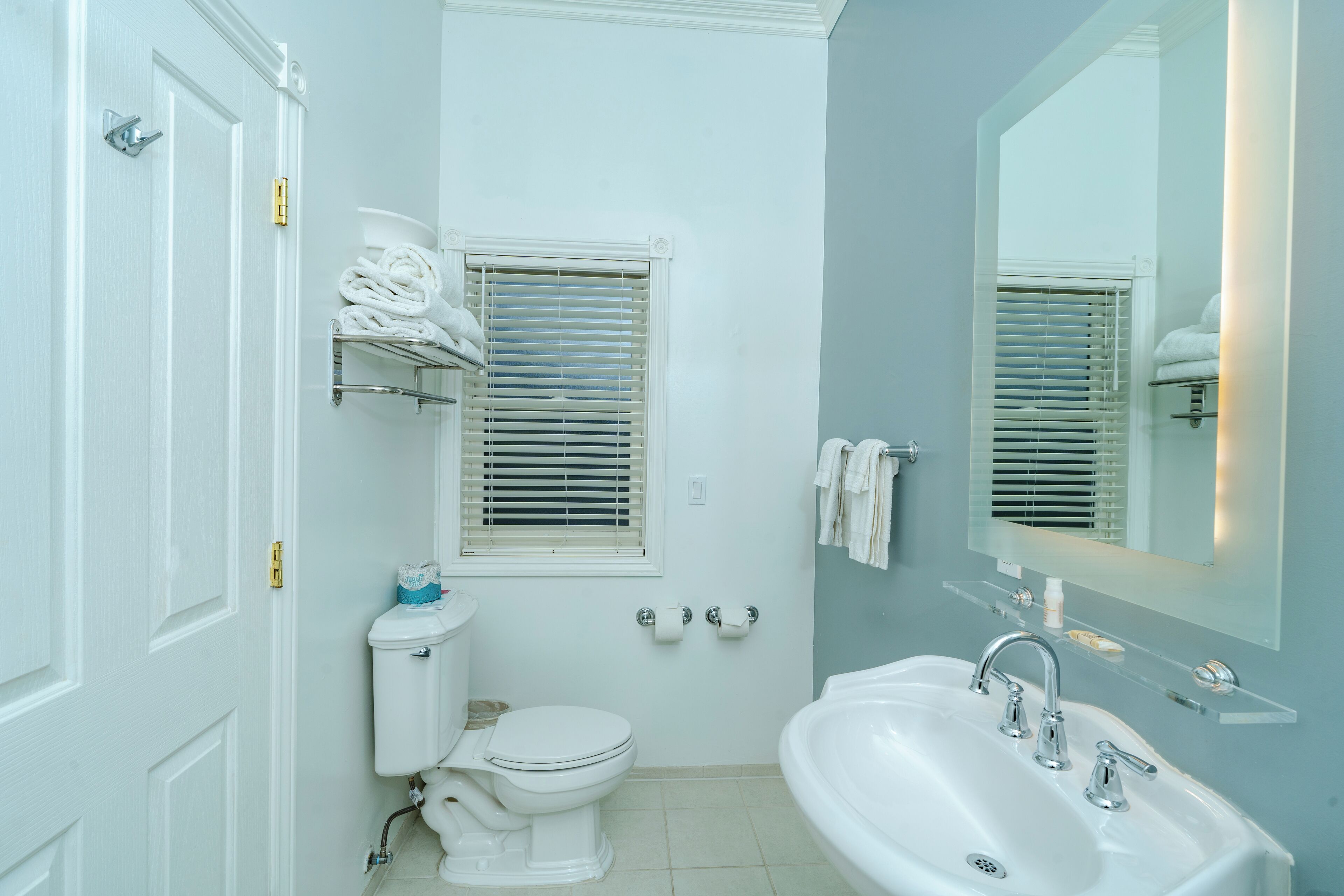Een badkamer met toilet, wastafel en handdoekhouder.