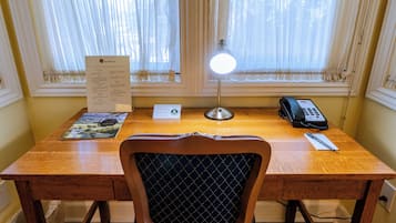A wooden desk with a lamp, a telephone, and a menu.