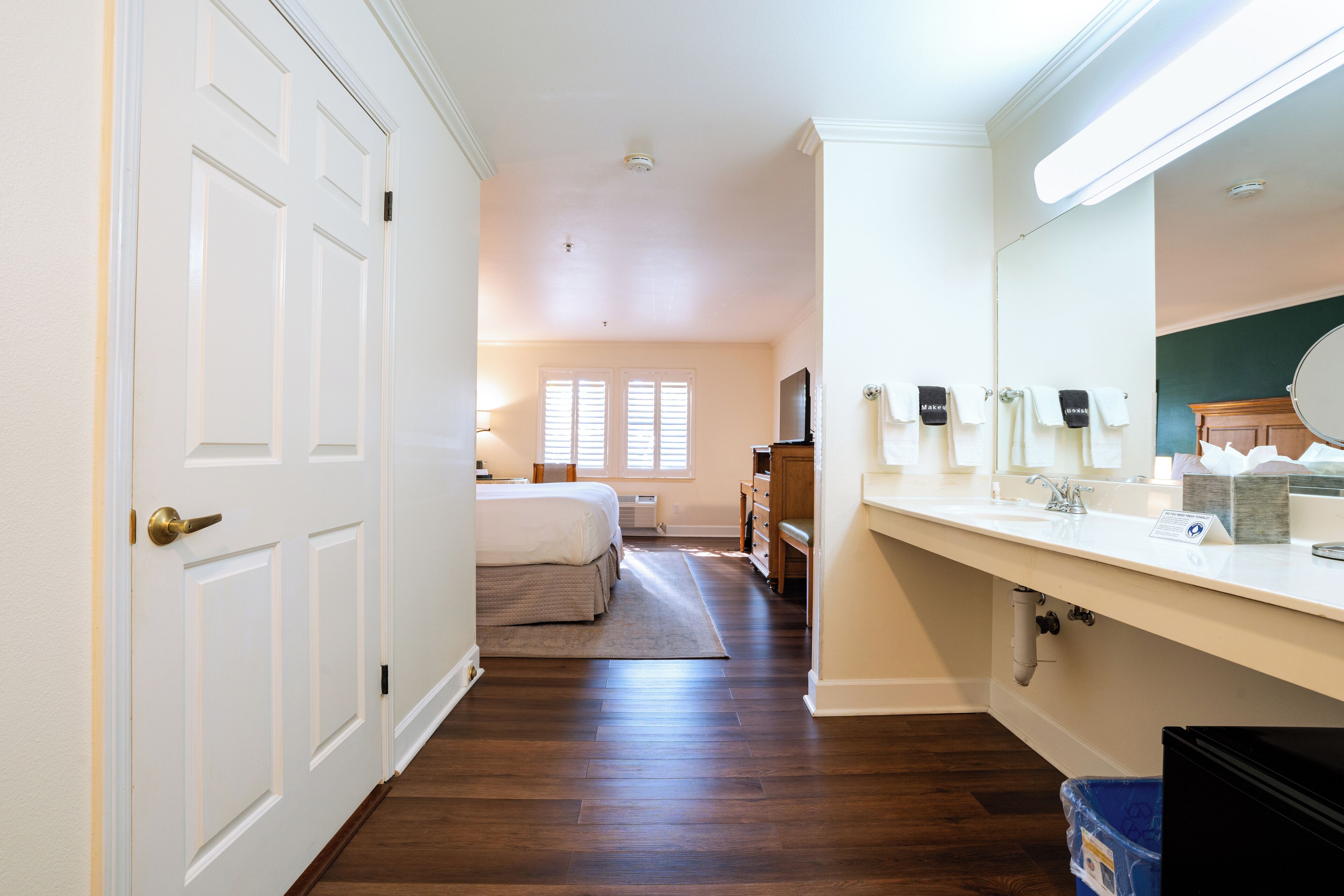 A bedroom with a bed, dresser, and a large mirror.
