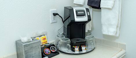 Eine Kaffeemaschine, eine Serviettenbox, ein Schild und ein Handtuchhalter mit Handtuch.
