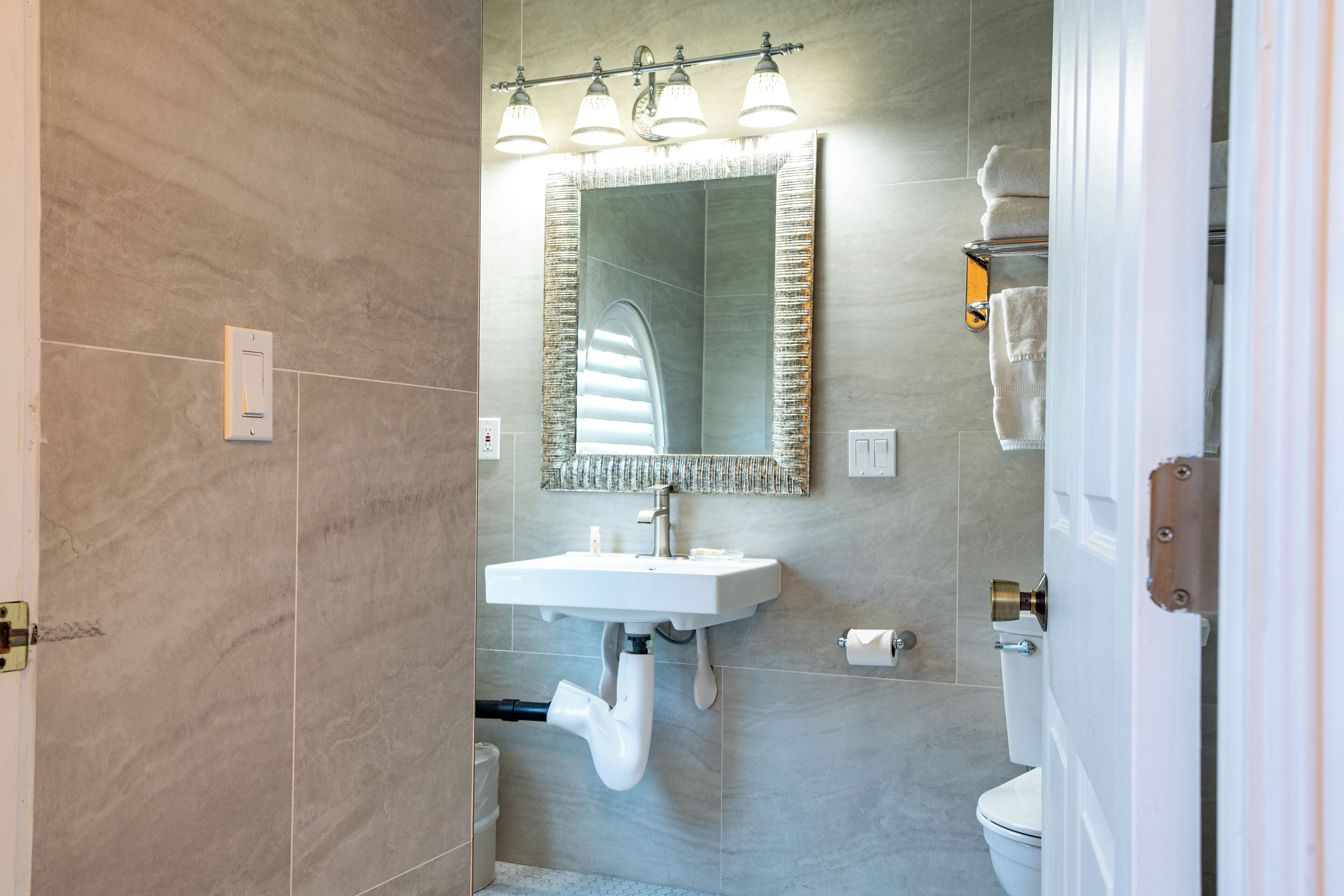 A modern bathroom with a built-in sink, a large mirror, and a toilet.