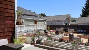 A cottage with a wooden deck, outdoor seating, and raised flower beds. - Elm House Inn (Napa)