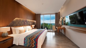 Una habitación de hotel moderna con una cama grande, un escritorio y un televisor.