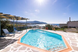 Una piscina al aire libre de temporada, tumbonas