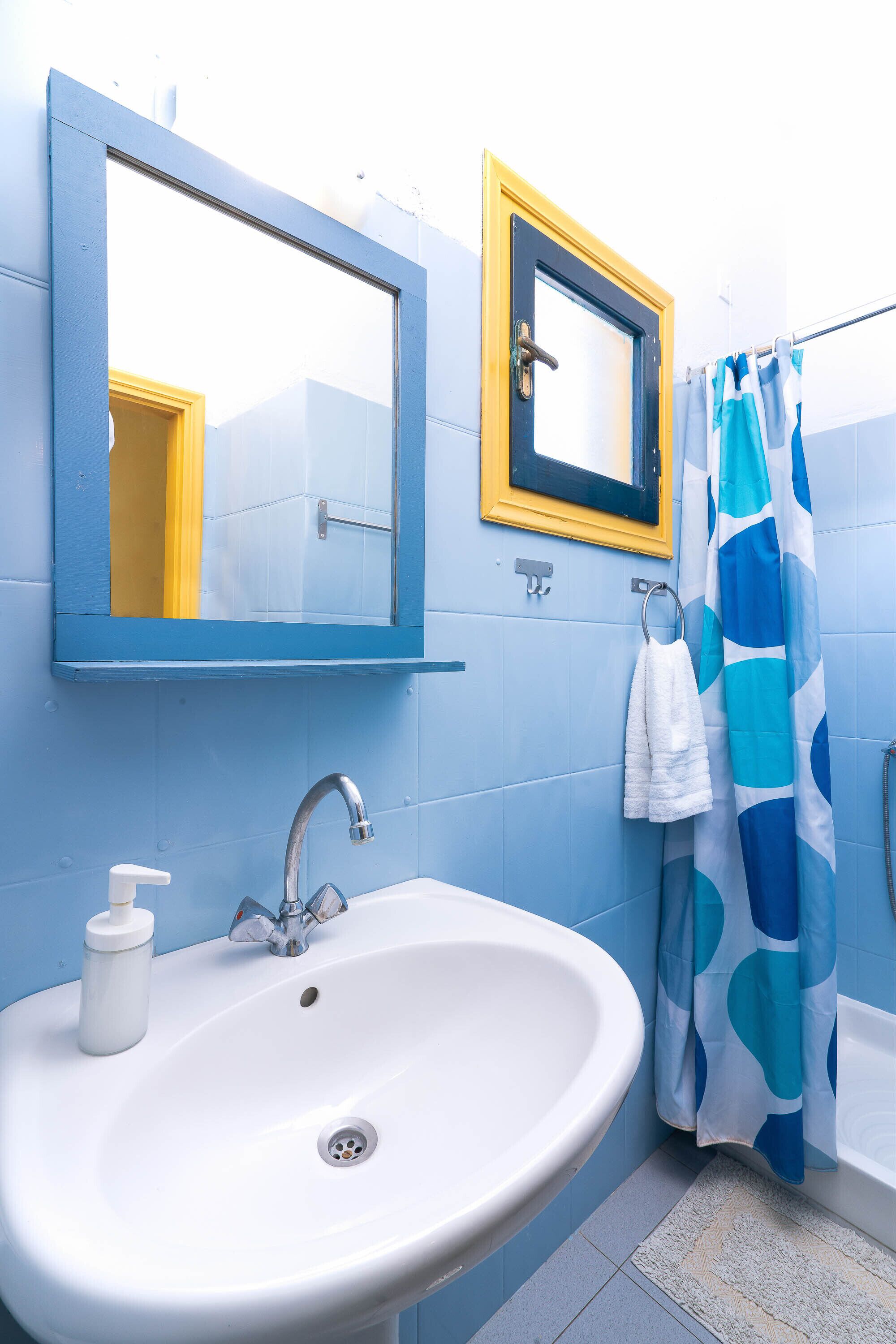 A bathroom with a white sink, a mirror, and a shower curtain.
