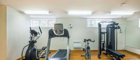 A gym with a treadmill, elliptical, stationary bike, and weight machines.