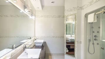 A modern bathroom with two sinks, a large mirror, and a glass-enclosed shower area.