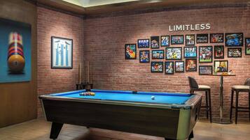 Enjoy a game of pool in a lively space with a pool table, sports memorabilia, and a bar area.