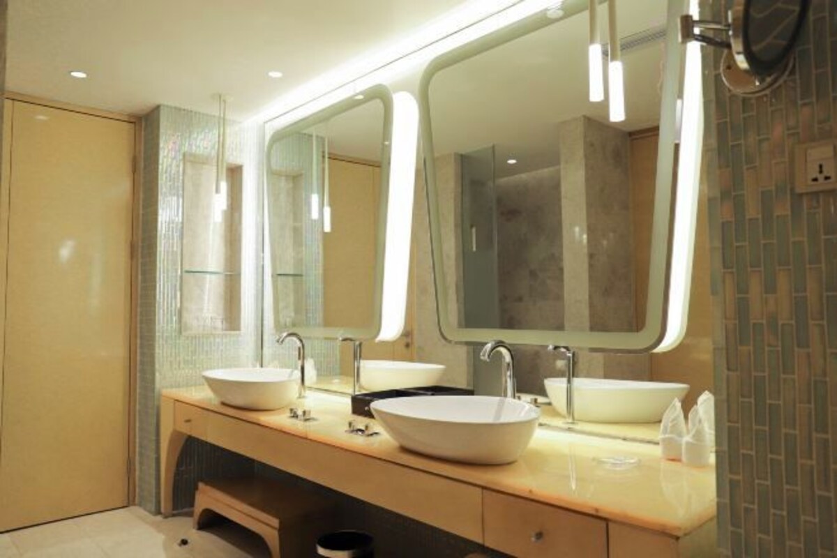 A modern bathroom with two sinks, large mirrors, and a tiled backsplash.