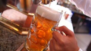 A hand pouring beer into a glass mug.