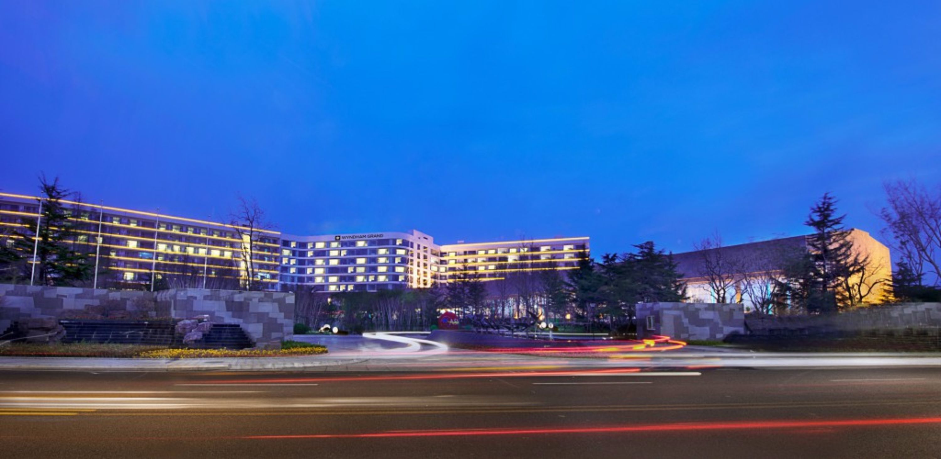 A multi-story hotel with a modern architectural design, featuring a prominent curved building and a series of connected structures.