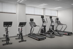 Gimnasio con cintas de correr, elípticas y bicicletas estáticas.