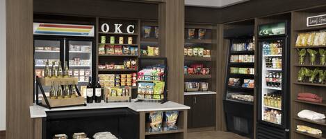 A self-service beverage station with a variety of drinks and snacks, including bottled water, soda, and snacks.