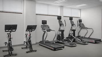 A fitness room with treadmills, ellipticals, and stationary bikes.