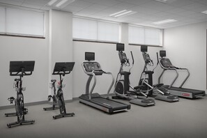 Una palestra attrezzata con tapis roulant, ellittiche e cyclette.