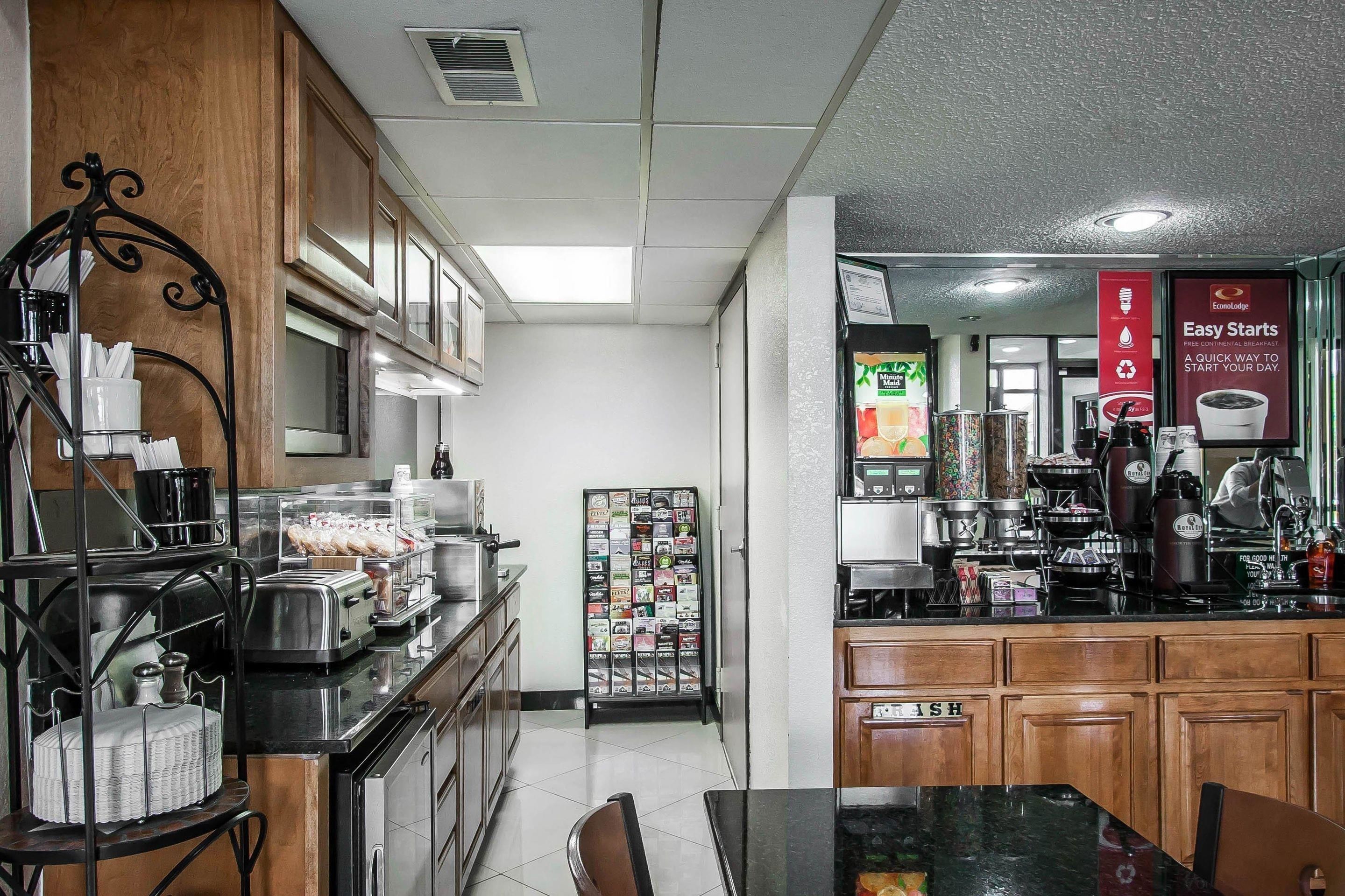 A kitchen with a coffee machine, toaster, and refrigerator. There is a menu board and a sign that says "Easy Starts".