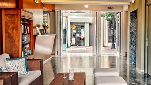 Un vestíbulo moderno con una recepción, un sillón amarillo y una estantería.