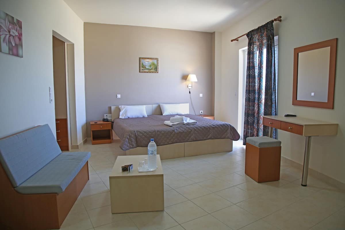 Une chambre à coucher comprenant un lit, une table de chevet, un bureau, une chaise et une lampe de chevet.
