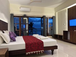 Habitación de hotel con una cama, televisión y vistas al océano.