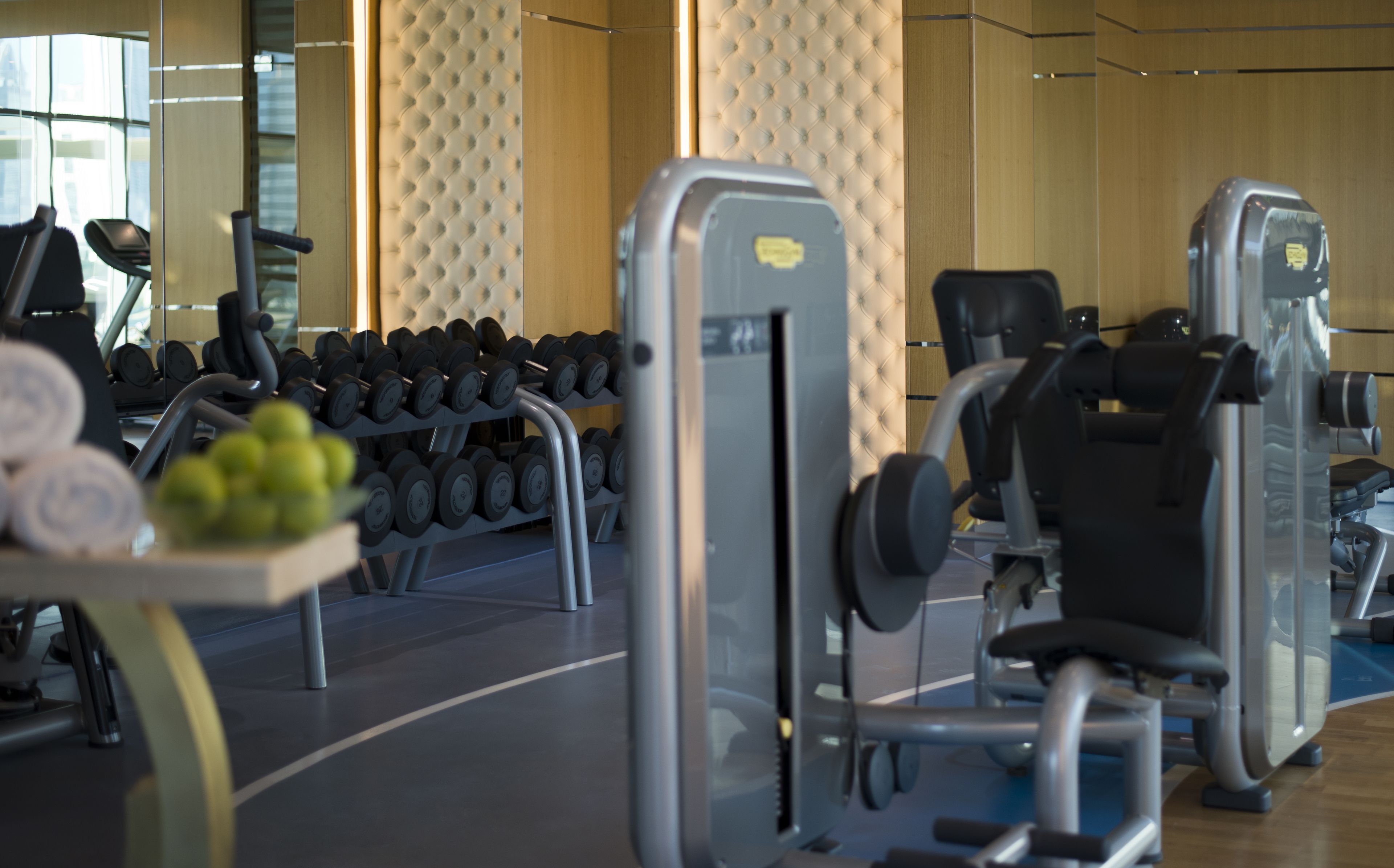 A gym with exercise equipment including dumbbells, a bench press, and a leg press.