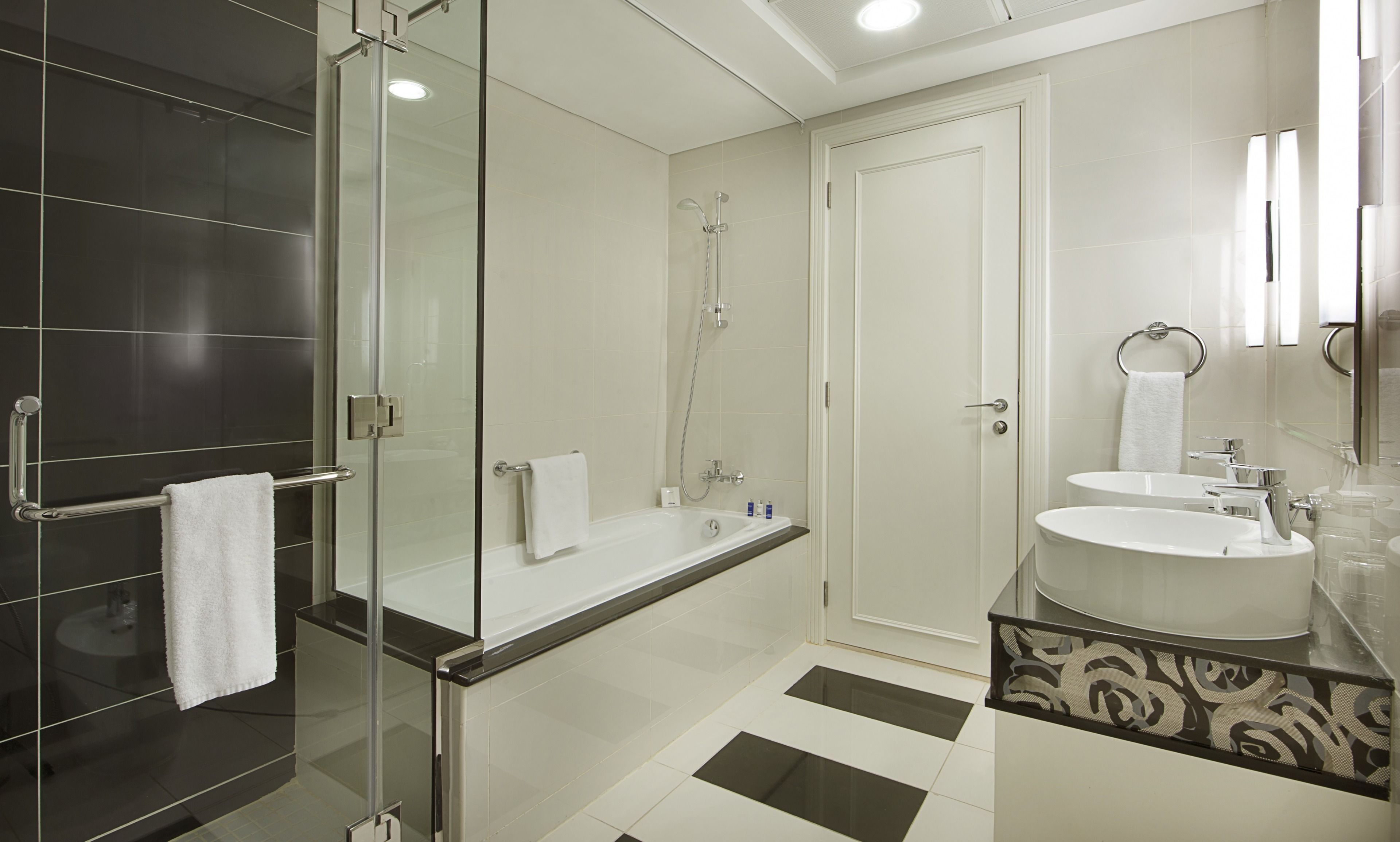 A modern bathroom with a glass-enclosed shower, a separate bathtub, and a vanity with a sink.