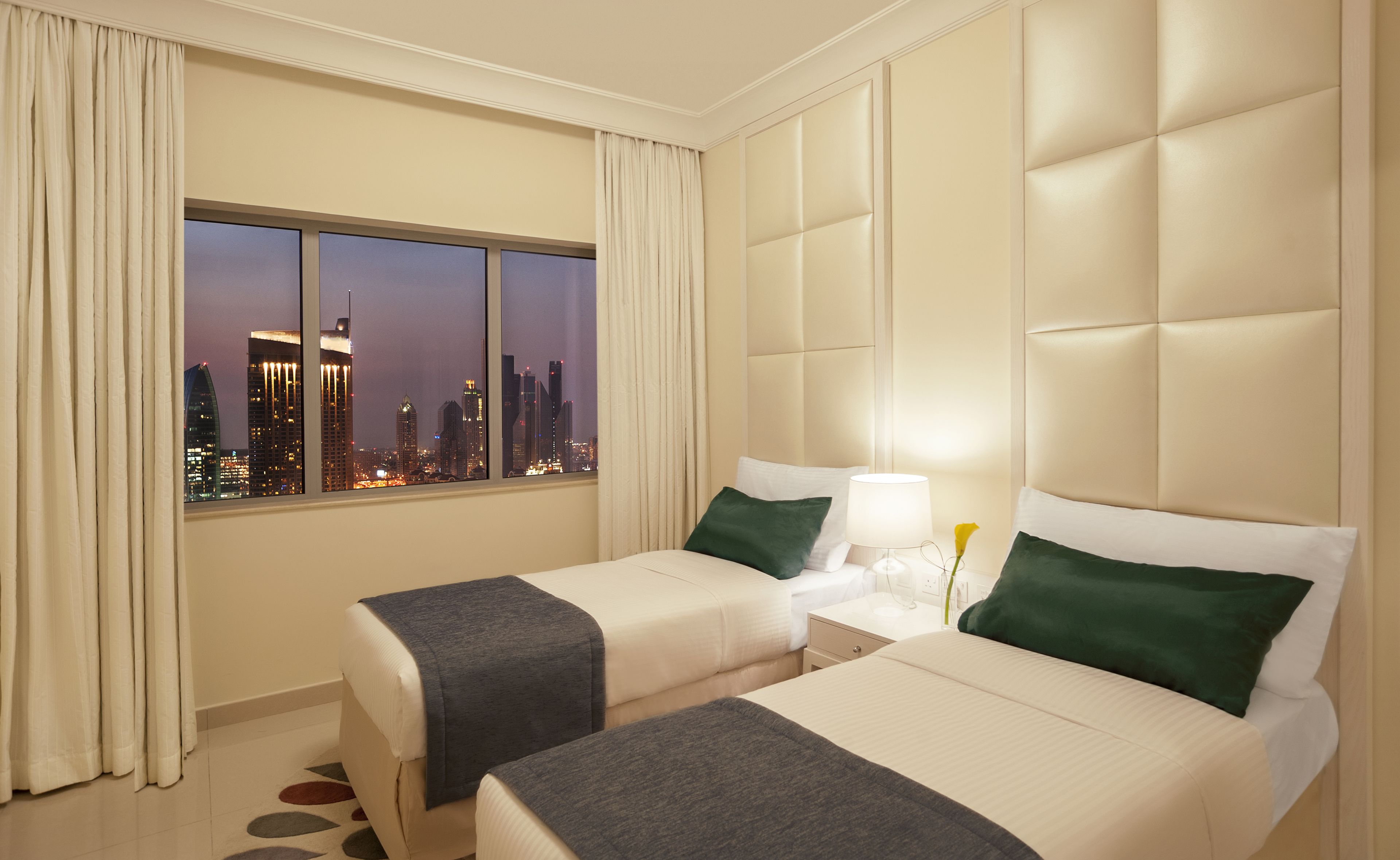 Quarto de hotel com duas camas, vista para a cidade e design moderno.
