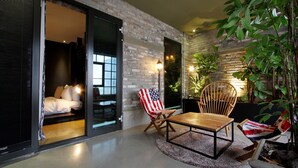 Een modern interieur met een bed, twee stoelen, een tafel en een grote plant.