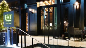 Een modern gebouw met een bord waarop staat: ‘EAT underground dining & lounge.’