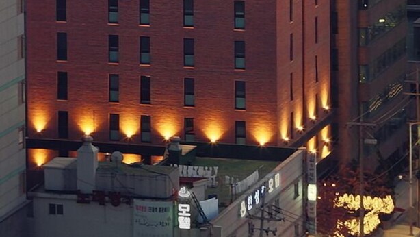 A tall brick building with the sign "HOTEL LOFT" at the top.