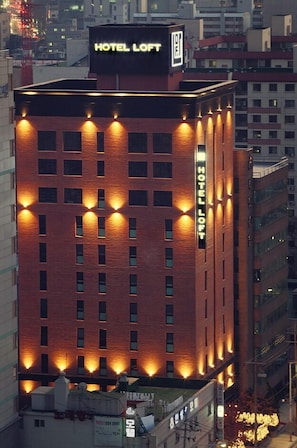 Korkea tiilinen rakennus, jonka päädyssä on kyltti, jossa lukee ”HOTEL LOFT”.