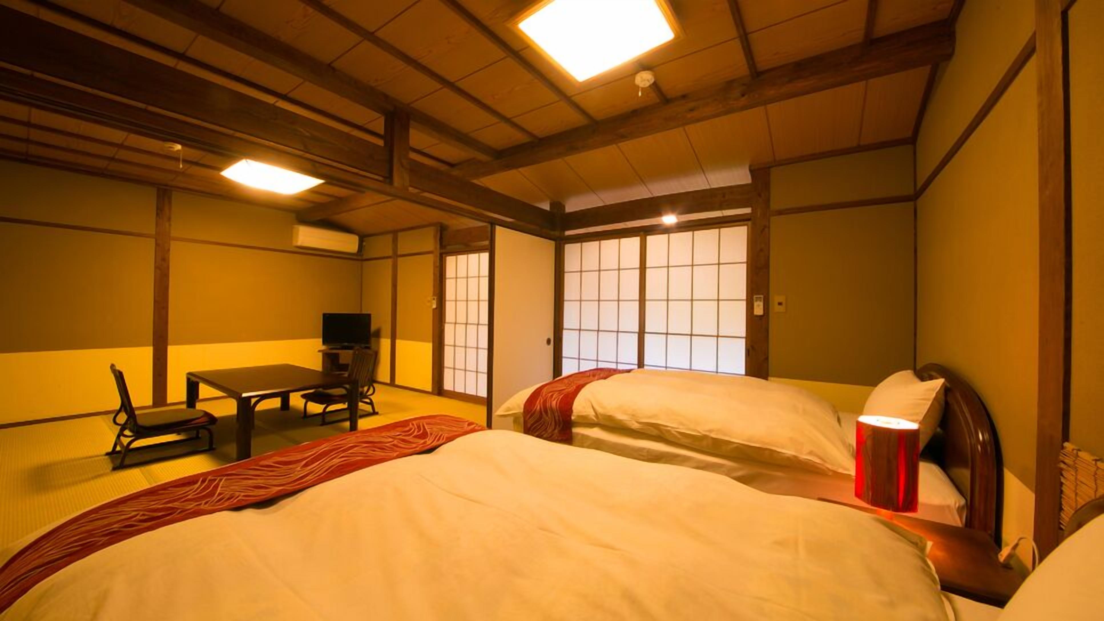 A traditional Japanese-style room with tatami flooring, a low table with a television, and sliding doors.