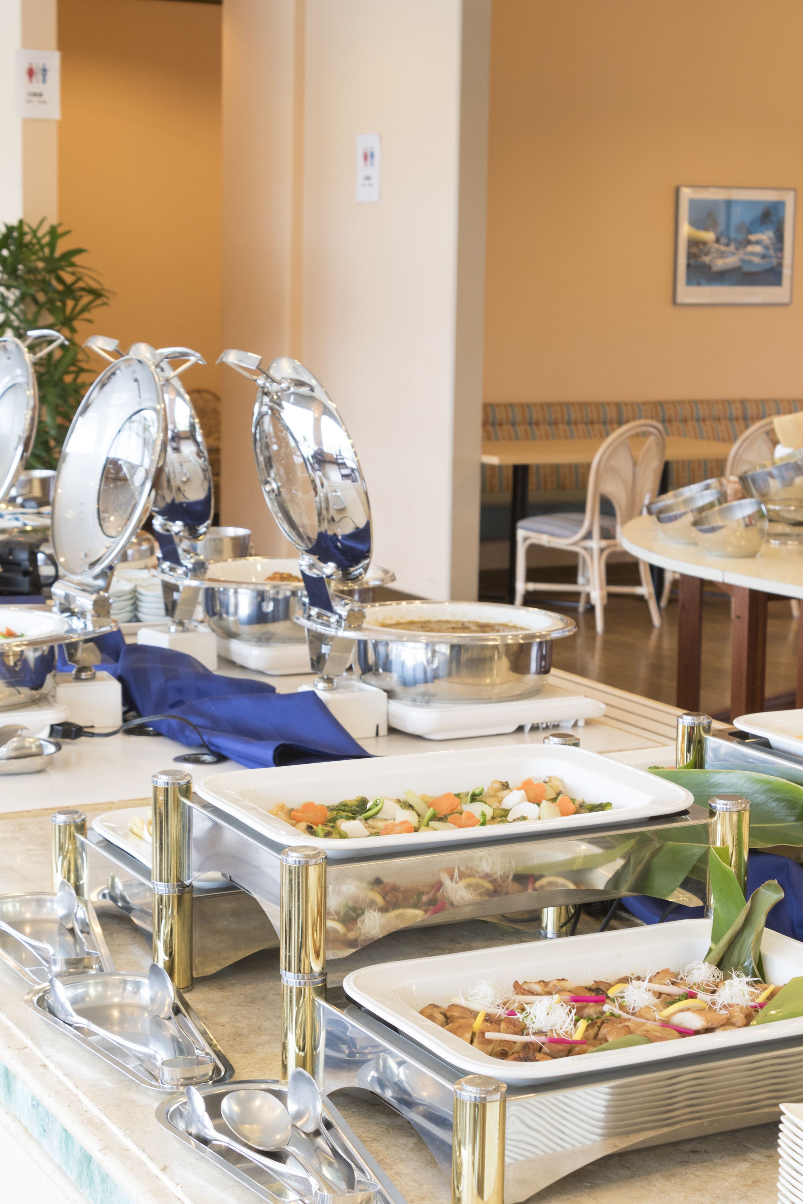 A buffet setup with various dishes and serving utensils.