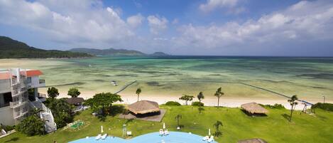 Un resort con una piscina grande, playa y vistas al océano.